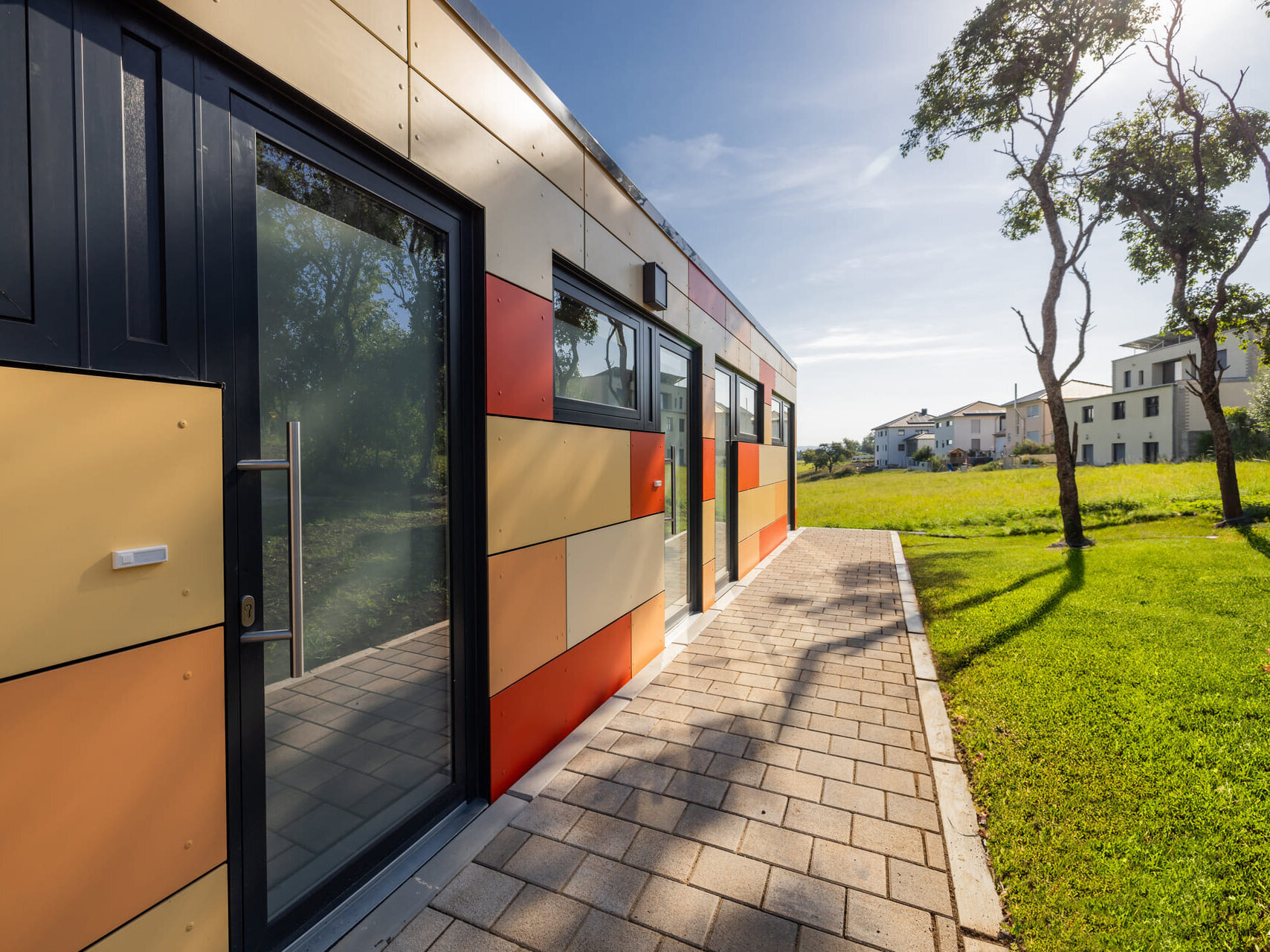 Eingangsbereich und farbige Fassade der XSCUBES-Wohnanlage in Dauchingen